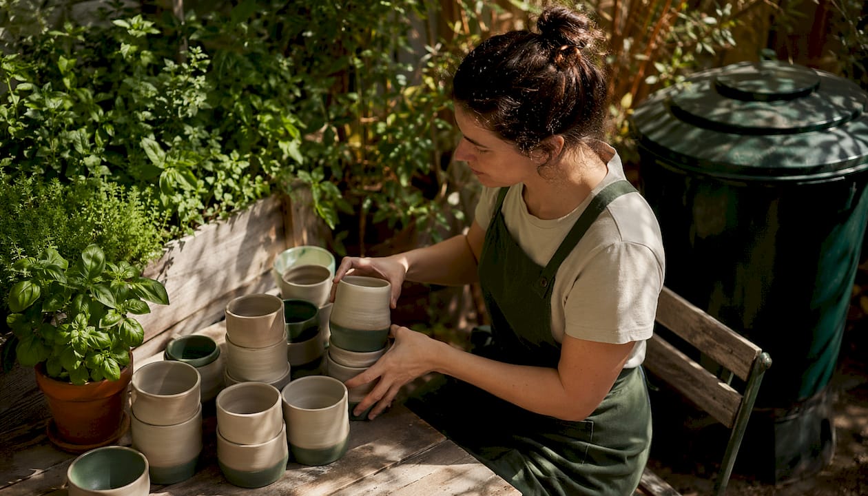 Barista arranging reusable coffee cups in café