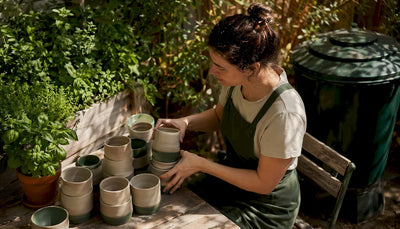 Barista arranging reusable coffee cups in café