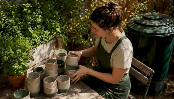 Barista arranging reusable coffee cups in café