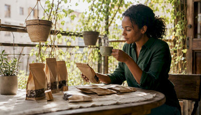 Person sampling sustainable coffee at kitchen table