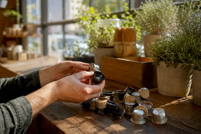 Hands inspecting used coffee pods for recycling