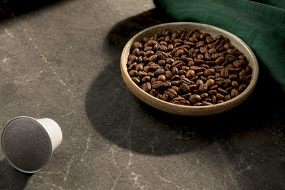 Coffee beans beside an anonymous coffee pod