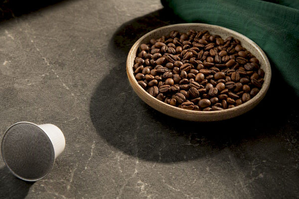 Coffee beans beside an anonymous coffee pod