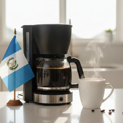 lifestyle picture with a coffee maker on a kitchen counter with a half-filled coffee pot with the Guatemala flag on one side and a cup of brewed coffee on the other side