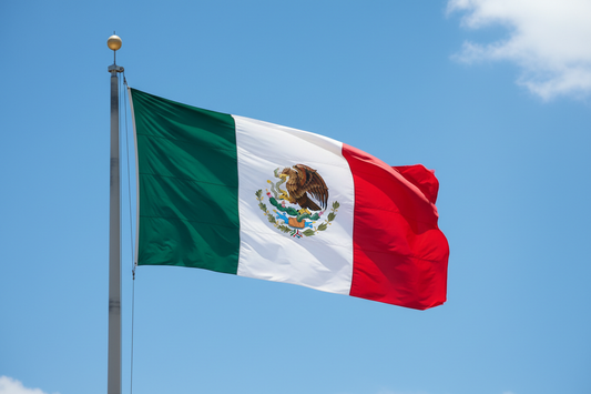 Mexico flag waving against blue sky representing Mexico coffee origin